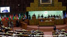 Pakistan Prime Minister Imran Khan, center, speaks during the 17th extraordinary session of Organization of Islamic Cooperation (OIC) Council of Foreign Ministers, in Islamabad, Pakistan, Sunday, Dec. 19, 2021. The economic collapse of Afghanistan, already teetering dangerously on the edge, would have a horrendous impact on the region and the world, successive speakers warned Sunday at the start of a one-day summit of foreign ministers. (AP Photo/Rahmat Gul)
