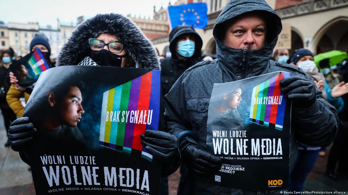 Dva muškarca na provsjedima drže plakate s natpisom "Slobodni ljudi, slobodni mediji"