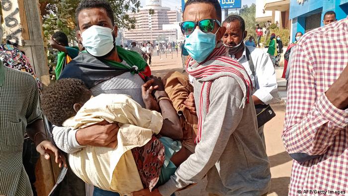 Men carrying an injured person in Khartoum, Sudan
