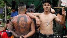 A fighter with a Suu Kyi tattoo poses with a fellow soldier