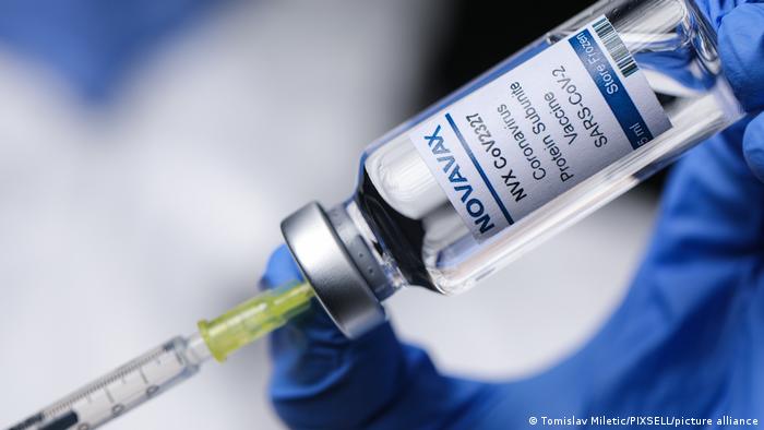 Syringe inserted into Novavax vaccine vial.