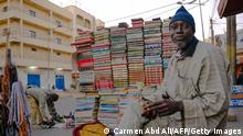 A book seller breaks the fast during the holy month of Ramadan in the Medina district of Dakar, on April 18, 2021. (Photo by CARMEN ABD ALI / AFP) (Photo by CARMEN ABD ALI/AFP via Getty Images) 