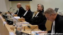 Lawyer for the victims, Peter Langstraat, second right, waits for the start of the ongoing trial and criminal proceedings regarding the downing of Malaysia Airlines flight MH17, at the high security court at Schiphol airport, near Amsterdam, Netherlands, Monday Dec. 20, 2021. Prosecutors are scheduled to begin explaining evidence and their case to judges Monday in the murder trial of three Russians and a Ukrainian charged with involvement in downing Malaysia Airlines flight MH17 over eastern Ukraine in 2014, killing all 298 passengers and crew. (AP Photo/Peter Dejong)