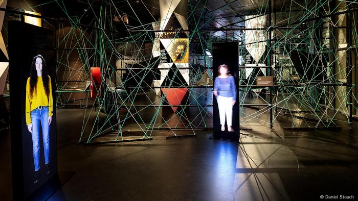 Green and blue ropes strung through exhibition spaces, along with digital images of two women