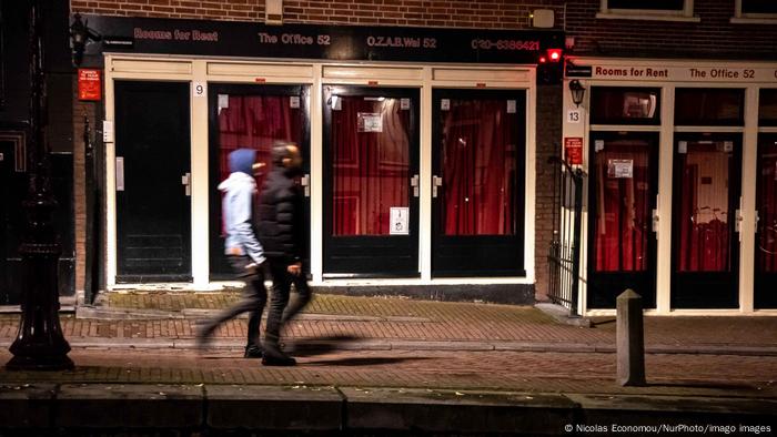 Deux hommes passant devant les magasins fermés