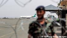 A member of security forces loyal to Yemen' Huthi rebels stands behind barbed wire at Sanaa International Airport on August 10, 2021, as employees of the rebel-held capital's airport hold a vigil demanding the facility's re-opening for humanitarian flights on the fifth anniversary of its closure. - Yemen's conflict flared in 2014 when the Huthis seized the capital Sanaa, prompting Saudi-led intervention to prop up the internationally recognised government the following year. The capital's airport has remained closed under a Saudi blockade since August 2016. (Photo by MOHAMMED HUWAIS / AFP) (Photo by MOHAMMED HUWAIS/AFP via Getty Images)