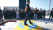 A policeman steps on a banner with the logo of broadcaster TVN modified to resemble a well known symbol of the anti-communist movement in Warsaw, Poland on August 10, 2021. American owned broadcaster TVN's license in Poland will expire at the end of September and the government has indicated it will not renew the license citing converns over it's forerign ownership. Critics argue the non-renewel is a move by the government to shut down critical media outlets. A new bill proposed by lawmakers prohibiting ownership of radio and television outlets by proprietors outside of the European Economic Area has led to fears of the end of independent media in Poland. (Photo by STR/NurPhoto)