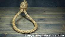 Hangman's knot on a rustic wooden table in a conceptual image of death penalty or suicide