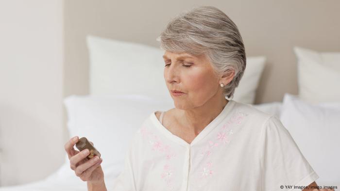 Woman looking at a bottle of pills