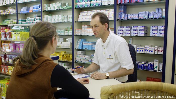 Женщина покупает лекартсва в аптеке