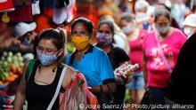 Women, wearing protective face masks as a precaution against the spread of the new coronavirus, shop at a local market in Asuncion, Paraguay, Tuesday, May 5, 2020. The government authorized the reopening of some businesses under a plan coined, intelligent quarantine”. (AP Photo/Jorge Saenz)