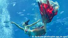HAIKOU, Dec. 21, 2021 -- A contestant participates in a mermaid contest in Sanya, south China s Hainan Province, Dec. 21, 2021. Over 40 contestants participated in the contest which kicked off Tuesday. CHINA-HAINAN-MERMAID CONTEST CN PuxXiaoxu PUBLICATIONxNOTxINxCHN