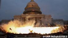An explosion caused by a police munition is seen while supporters of U.S. President Donald Trump gather in front of the U.S. Capitol Building in Washington, U.S., January 6, 2021. Reuters photographer Leah Millis: Thousands of supporters of then-President Donald Trump, a Republican, stormed the U.S. Capitol on Jan. 6 in a failed attempt to overturn the recent election and prevent Joe Biden, a Democrat, from becoming the next president. It was the worst attack on the seat of the U.S. government since the War of 1812. I arrived at the west side of the U.S. Capitol before the Trump supporters overwhelmed police lines, and I documented the chaos that ensued for the next seven hours. At one point I heard the crowd chanting heave-ho and thought they must be breaking in through the doors. I didn't want to risk getting crushed or injured by the massive crowd, which was hostile toward members of the media and had already assaulted several of my colleagues that day. I chose to risk climbing some scaffolding that had been erected for the upcoming inauguration to give me a better view. The Capitol had already been breached via different entrances, but the fight for this entrance went on for hours. Capitol and D.C. Metropolitan police officers engaged in hand-to-hand combat with the mob of Trump supporters and in the process multiple officers were severely injured. Four people would die that day and a police officer attacked by protesters died the next day. Four officers later took their own lives. Eventually, law enforcement was able to successfully push the crowd back. At 5:04 p.m. to disperse the remaining protesters, they used a flash-bang grenade, which released a blinding light that illuminated the U.S. Capitol building. To me, the explosion of the grenade captured the violence and shock of the day: American citizens attacking and breaching their own country's Capitol building. The haunting sight of the American flag flying above the entire scene, casting a shadow onto