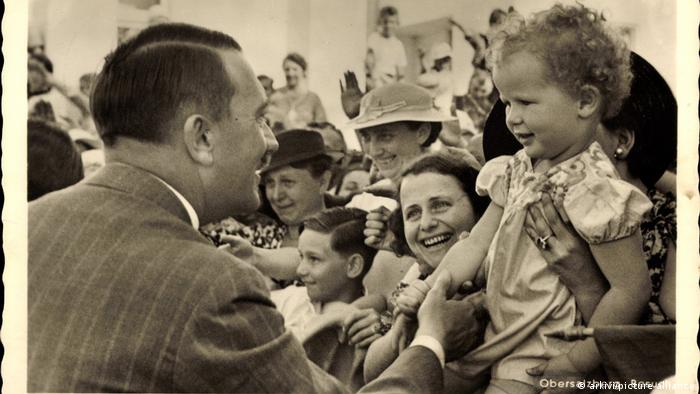 Postkarte: Adolf Hitler streichelt ein Kind, die Menge jubelt ihm zu 