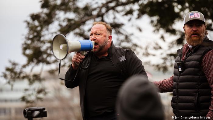 Alex Jones addresses a crowd of pro-Trump protesters with a megaphone after they storm the grounds of the Capitol Building