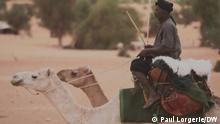 A nomadic police officer rides a camel in Mauritania