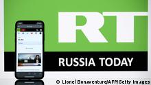 A picture taken on October 5, 2021 in Toulouse shows the logo of RT (Russia Today) tv channel displayed by a screen as a smartphone displays RT's live broadcast in Toulouse. (Photo by Lionel BONAVENTURE / AFP) (Photo by LIONEL BONAVENTURE/AFP via Getty Images)