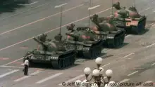 A Chinese man stands alone to block a line of tanks heading east on Beijing's Cangan Blvd. in Tiananmen Square on June 5, 1989. The man, calling for an end to the recent violence and bloodshed against pro-democracy demonstrators, was pulled away by bystanders, and the tanks continued on their way. The Chinese government crushed a student-led demonstration for democratic reform and against government corruption, killing hundreds, or perhaps thousands of demonstrators in the strongest anti-government protest since the 1949 revolution. Ironically, the name Tiananmen means Gate of Heavenly Peace. (AP Photo/Jeff Widener)