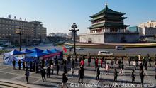 In this photo released by China's Xinhua News Agency, residents line up for tests at a COVID-19 testing site in Xi'an in northwestern China's Shaanxi Province, Tuesday, Dec. 21, 2021. China on Wednesday ordered millions of people locked down in neighborhoods and workplaces in the northern city of Xi'an following a spike in coronavirus cases. (Li Yibo/Xinhua via AP)