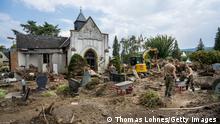 BAD NEUENAHR-AHRWEILER, GERMANY - AUGUST 04: Soldiers of the German Armed Forces work with shovels, wheelbarrows and excavators on the flood-damaged cemetery during ongoing cleanup efforts in the Ahr Valley region following catastrophic flash floods on August 04, 2021 in Bad Neuenahr-Ahreweiler, Germany. Villages along the Ahr river as well as other towns and villages across western Germany are attempting to recover from devastating floods in mid-June that left at least 170 people dead, hundreds injured and approximately 70 still missing. (Photo by Thomas Lohnes/Getty Images)