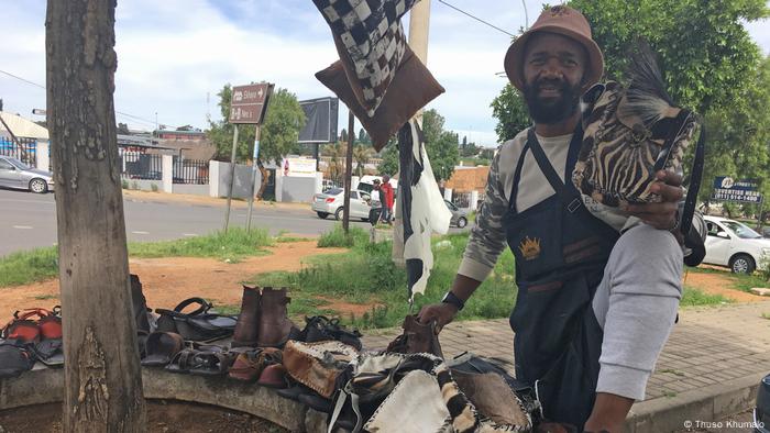 Shaka Zulu beside a street stall on Vilakazi Street in Soweto, where he sells a variety of products adorned with cow skin