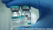 A Turkish Health Ministry official holds a vial of TURKOVAC, the country's first locally-developed COVID-19 vaccine, in Sanliurfa, Turkey, Wednesday, Dec. 22, 2021. Turkey's drugs authority has granted emergency use approval for TURKOVAC, Turkish officials announced Wednesday. (Turkish Health Ministry via AP)