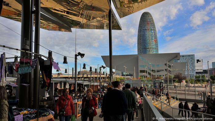 Gente caminando cerca de puestos en el Mercat dels Encants en Barcelona, ​​​​España