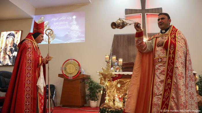 Iraqi priests wearing protective masks amid the COVID-19 pandemic, hold the Christmas eve mass at the Sultana church in the Ankawa suburb north of Arbil.