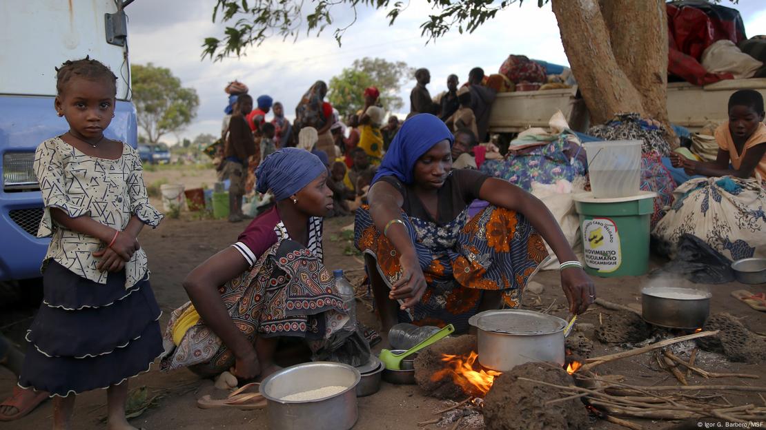 Mulher e crianças africanas cozinhando ao ar livre