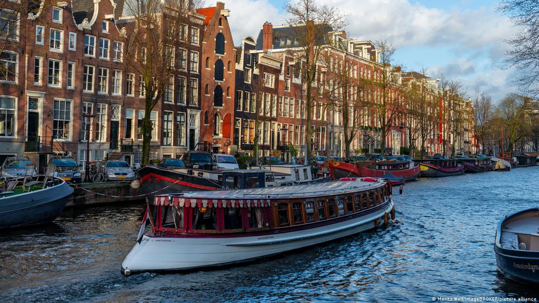 Boat on a canal, with typical Dutch warehouse in the background