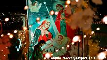 A Christian gives final touches to an enclosure specially decorated for Christmas celebrations, at a Christian neighborhood of Islamabad, Pakistan, Friday, Dec. 24, 2021. (AP Photo/Anjum Naveed)