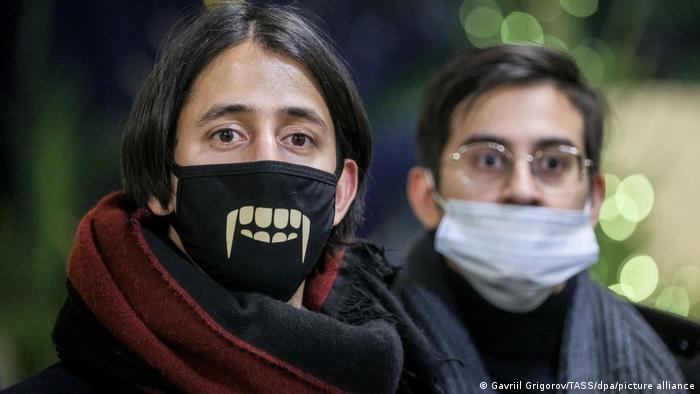 Two people wearing masks and scarfs.