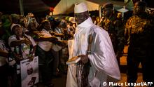 (FILES) This file photo taken on November 24, 2016 shows then Gambia's incumbent President Yahya Jammeh (C), leader of the APRC (The Alliance for Patriotic Reorientation and Construction), smiling while being greeted by supporters as he arrives at a campaign rally in Brikama, ahead of the December 1 presidential election. - A Truth and Reconciliation commission investigating crimes committed during Yahya Jammeh's 22-year rule in The Gambia has recommended that the former dictator be prosecuted in an international court, in a report released on December 24, 2021, in Banjul. (Photo by Marco LONGARI / AFP)