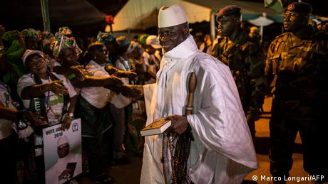 Former Gambian President Yahya Jammeh wears white and is backed by soldiers