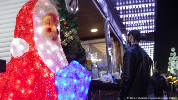 A man wearing a mask in front of Christmas decorations