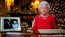 FILE PHOTO: Britain's Queen Elizabeth records her annual Christmas broadcast in the White Drawing Room in Windsor Castle, next to a photograph of the queen and the Duke of Edinburgh, in Windsor, Britain, December 23, 2021. Victoria Jones/Pool via REUTERS/File Photo