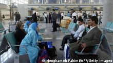 TEHRAN, IRAN: Iranian passengers wait with their baggage in Tehran's newly re-opened Imam Khomeini airport 30 April 2005. The Iranian capital's new showpiece airport finally reopened today a year after being shut down by the armed forces, but was immediately hit by fresh controversy amid warnings its runway may not yet be safe. AFP PHOTO/HENGHAMEH FAHIMI (Photo credit should read HENGHAMEH FAHIMI/AFP via Getty Images)