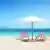 Cadeiras de praias vazia sob um guarda-sol em praia paradisíaca