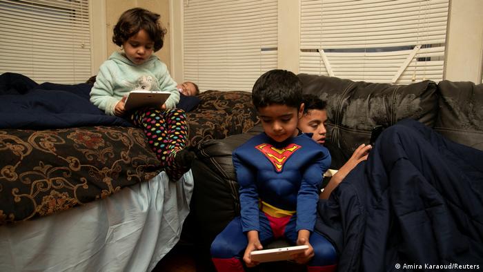 Die Geschwister Sanaullah Khan Zadran, 6, als Superman verkleidet, Zahra Zardan, 4, und sein Bruder Samiullah Khan Zadran, 13, spielen mit ihren Tablets. Die Regierung der Vereinigten Staaten führt derzeit die größte Flüchtlingsevakuierung seit Vietnam durch. Von den fast 75.000, die sich in Amerika niederlassen sollen, wird Bowling Green im Haushaltsjahr 2022 350 Afghanen aufnehmen. REUTERS/Amira Karaoud 