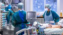 ARCHIV - 30.11.2021, Mecklenburg-Vorpommern, Rostock: Ärzte und Pflegekräfte betreuen einen Patienten bei einer Lungenspiegelung in einem der Behandlungszimmer auf der Intensivstation in der Universitätsmedizin Rostock. Die vierte Corona-Welle scheint zumindest etwas abzuklingen. Doch Omikron könnte die Entwicklung schon bald wieder umkehren. (zu dpa: Corona-Lage entspannt sich offenbar etwas - aber Omikron lauert schon) Foto: Jens Büttner/dpa-Zentralbild/dpa +++ dpa-Bildfunk +++
