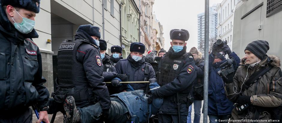 Homem é carregado ao ser preso por policiais em frente a tribunal em Moscou, por prostestar em favor da Memorial