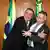 Presidente Jair Bolsonaro sorri e abraca ministro André Mendonça, que parece se esquivar do abraço 