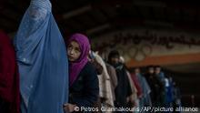 Women queue to receive cash at a money distribution site organized by the World Food Program in Kabul, Afghanistan, on Saturday, Nov. 20, 2021. Thousands of Afghan families are registering for WFP aid because they cannot afford food during the country's economic collapse. (AP Photo/Petros Giannakouris)