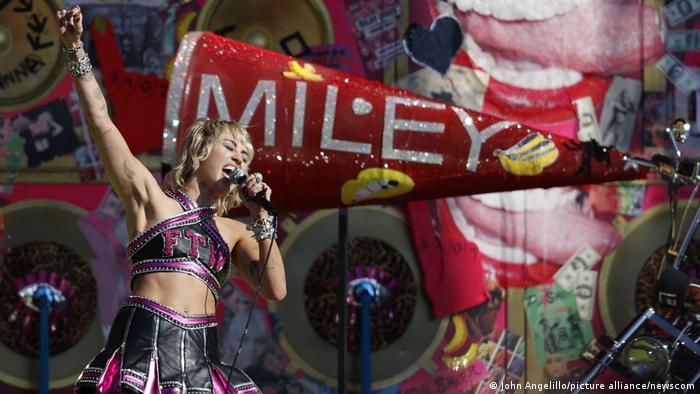 Miley Cyrus performs on stage with a microphone