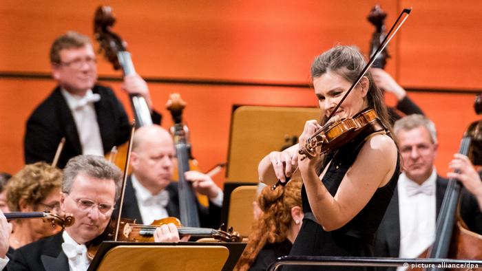Janine Jansen plays violen with an orchestra 
