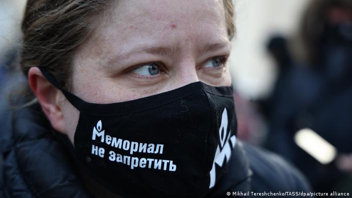 Участник акции в Москве в маске с надписью Мемориал не запретить