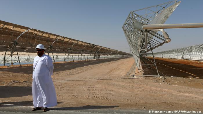 An Emirati stands in front of rows of parabolic mirrors at the Shams 1 Concentrated Solar Power (CSP) plant, in al-Gharibiyah district on the outskirts of Abu Dhabi.