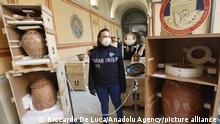 A Carabinieri officer of Cultural Heritage Protection Command stands by findings displayed during a press conference on the fight against illegal trafficking of cultural assets in Rome