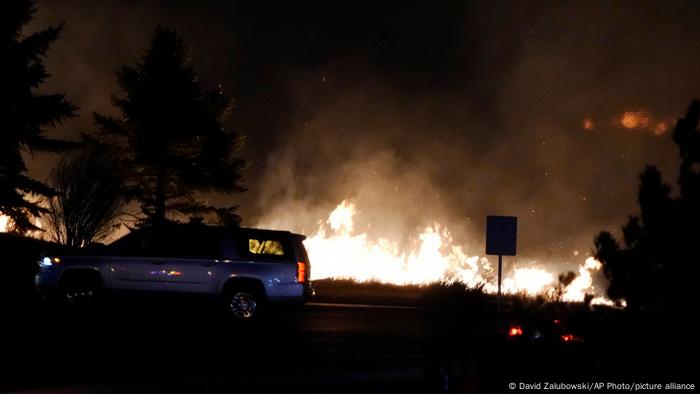 Flames explode as wildfires burned near a small shopping center