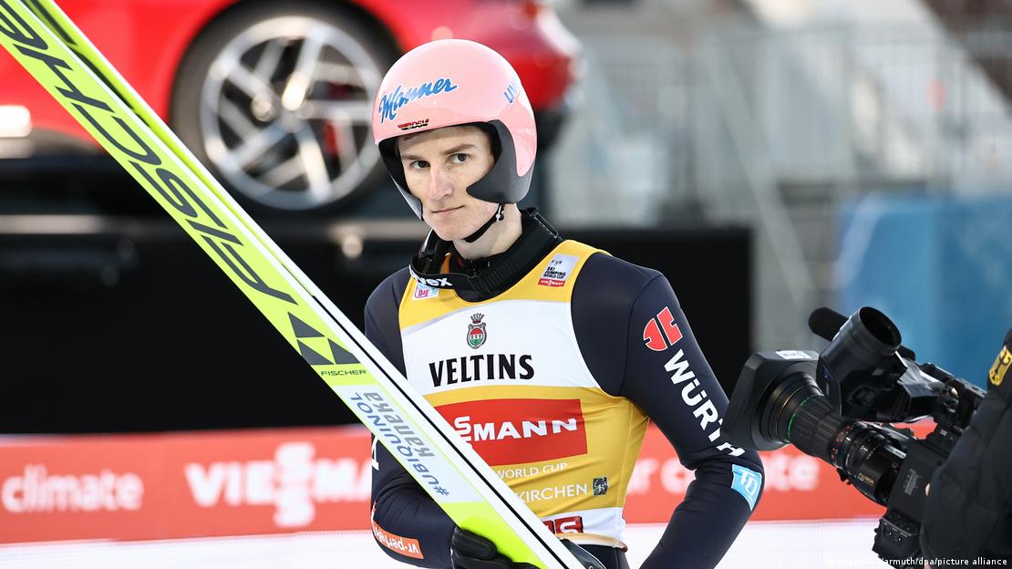 Karl Geiger holds his skis during a competition